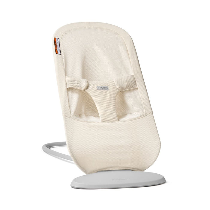 A  baby bouncer seat in cream fabric with a light gray base, shown on a clean white background.