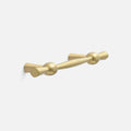 Angled view of Eleanor Pull showcasing curved solid brass bow tie design with a light background