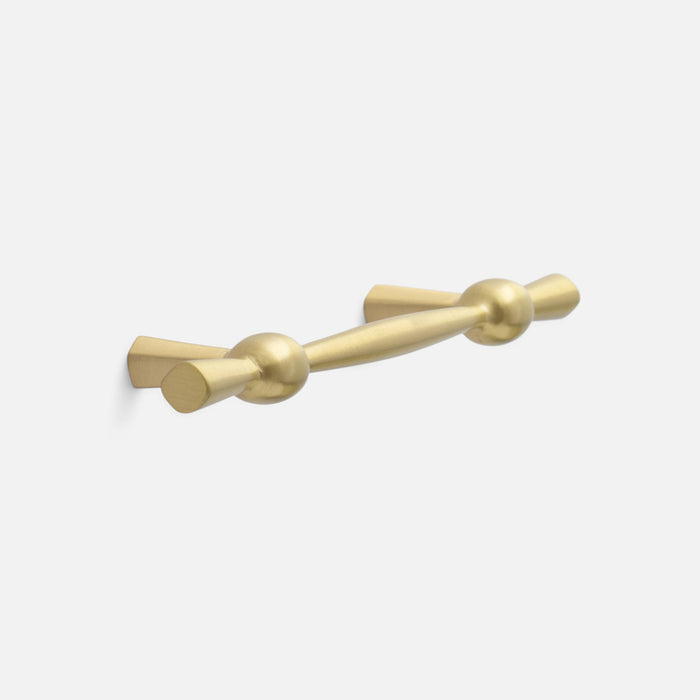 Angled view of Eleanor Pull showcasing curved solid brass bow tie design with a light background