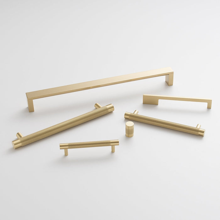 Overhead view of Knurled Knob showcasing its cross-hatched brass texture among matching cabinet hardware