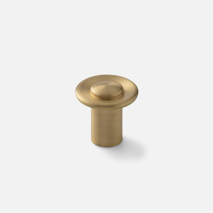 Front view of Landon Knob showcasing its round brass-toned face and cylindrical base against a light gray background