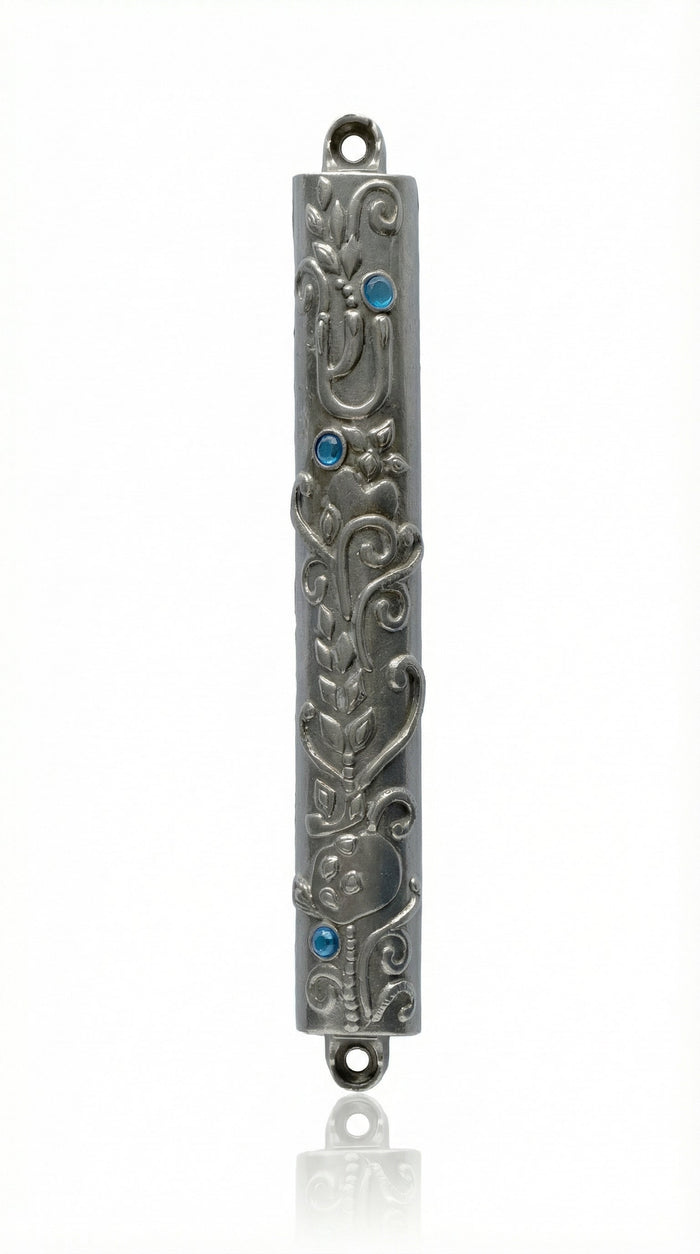 High-resolution image of an Ofir Mezuzah made of pewter, standing 7 inches tall, with intricate engraved Hebrew letters and decorative motifs, on a white studio background with soft reflection.