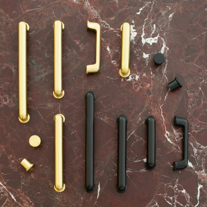 Overhead view of Remy Pull hardware showcasing gold and black finishes on red marble