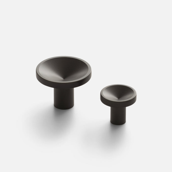 Close-up of two Rhone Knob sizes showcasing textured recessed faces and cylindrical stems on a white background