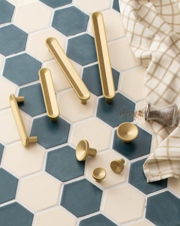 Top-down view of Rhone Pulls in cast brass on blue and cream hexagonal tiles