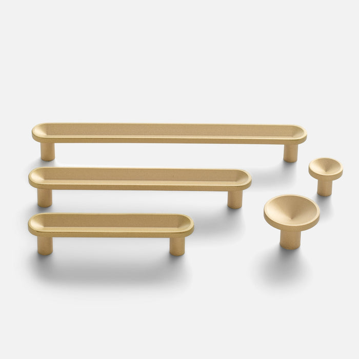 Front view of Rhone Pull in cast brass showcasing elongated and cup-shaped designs on a white background