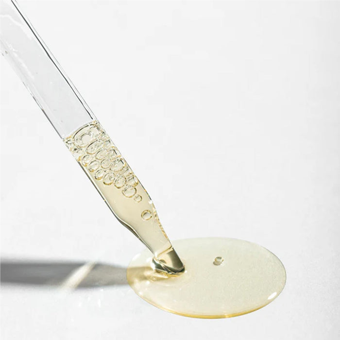 Shop Rescue Spa Scalp Booster Pre-Wash clear serum dripping from a glass dropper onto a white surface