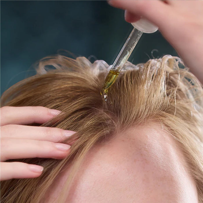 Shop Rescue Spa Scalp Booster Pre-Wash being applied to blonde hair with a glass dropper for scalp treatment