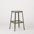 Three-quarter view of Schoolhouse Utility Stool 26-inch showing stamped seat, welded steel frame, and rubber feet on light background