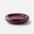 Front view of Yves cast metal catch-all showcasing glossy raisin finish and rounded low-profile shape on a white background