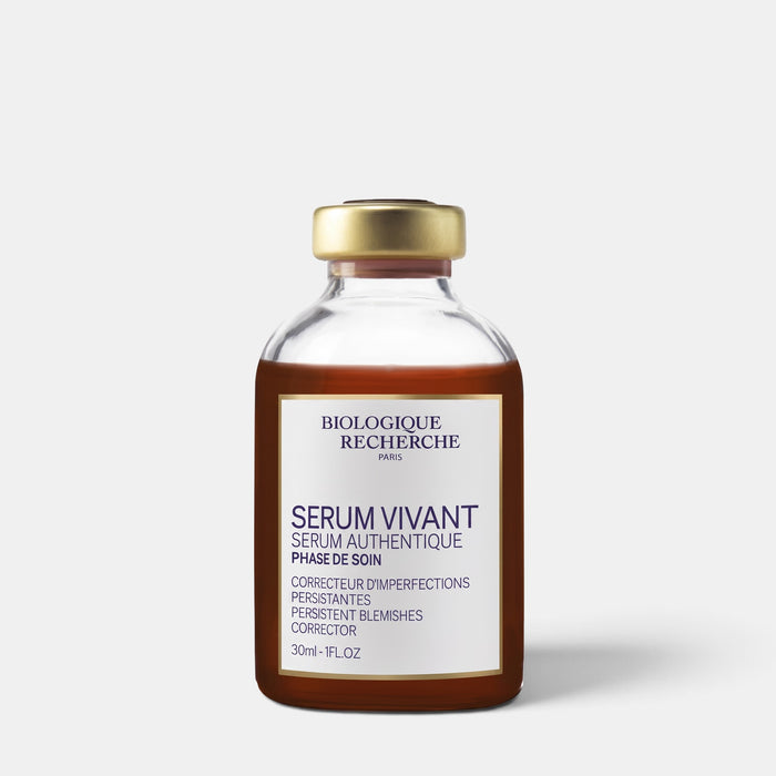 A 30ml glass vial of Biologique Recherche 'Serum Vivant' blemish corrector, featuring a gold cap and a cream-colored label with dark blue text, set against a light gray background.