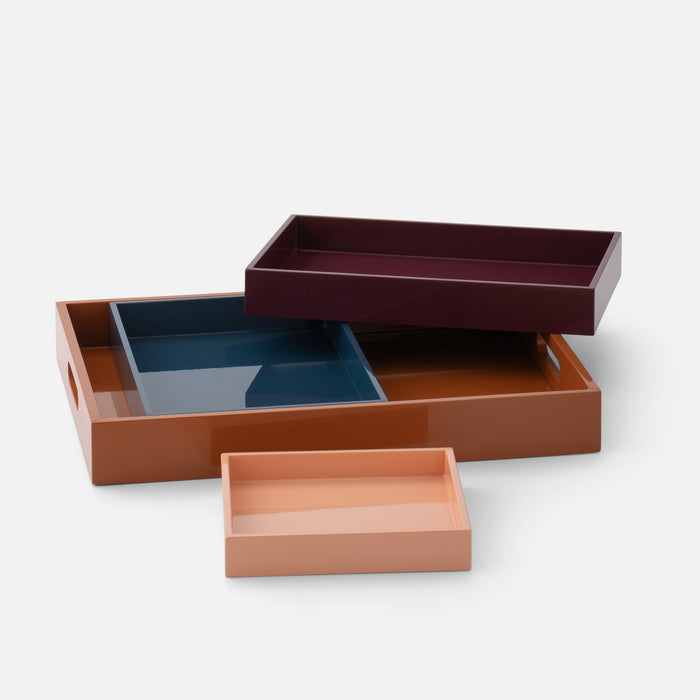 Angled view of Stacking Trays, Set of 4 showcasing four nesting trays with lacquer finish on a white background